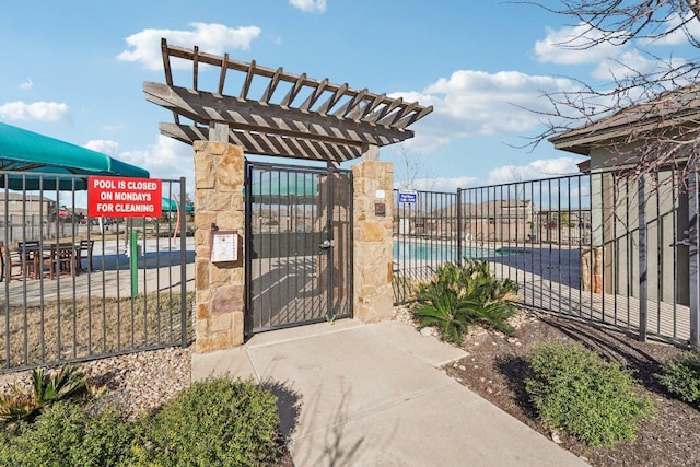 view of gate with a pergola and fence