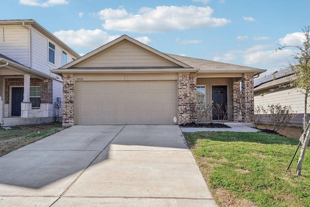 view of front of home featuring brick siding, a front lawn, concrete driveway, and a garage