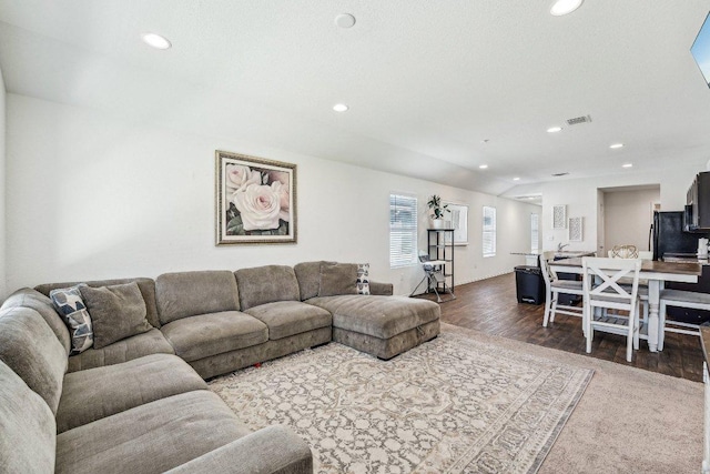 living room featuring recessed lighting, visible vents, lofted ceiling, and dark wood finished floors