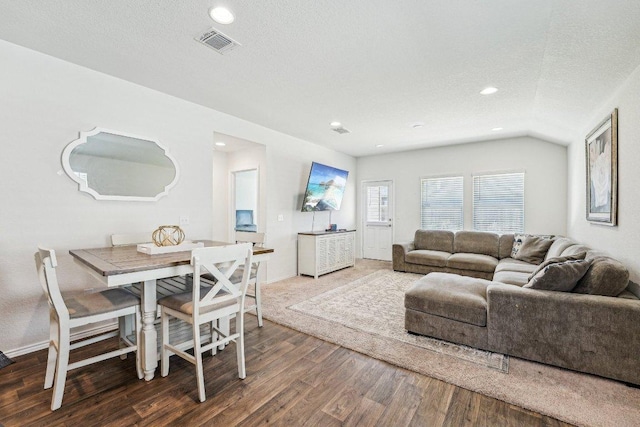 living room featuring wood finished floors, visible vents, lofted ceiling, recessed lighting, and a textured ceiling