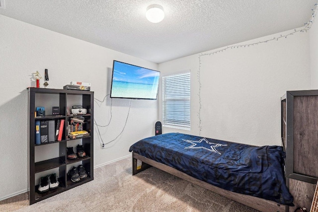 bedroom with baseboards, carpet floors, and a textured ceiling