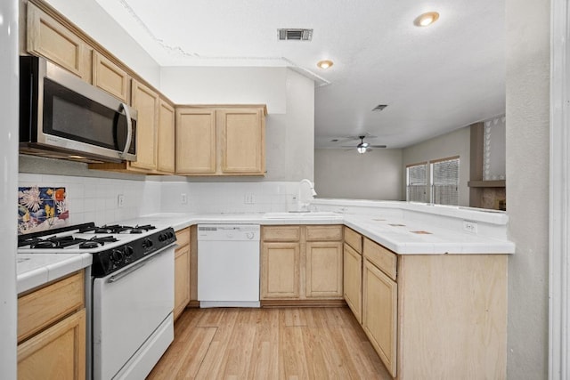 1100 Silverton Ct, Austin, TX 78753 - kitchen featuring white appliances, light brown cabinets, tile countertops, a sink, and a ceiling fan