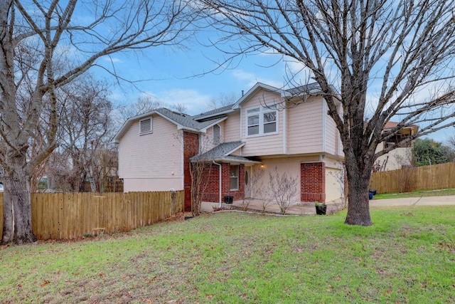 view of front of home with fence, driveway, a front lawn, a garage, and brick siding