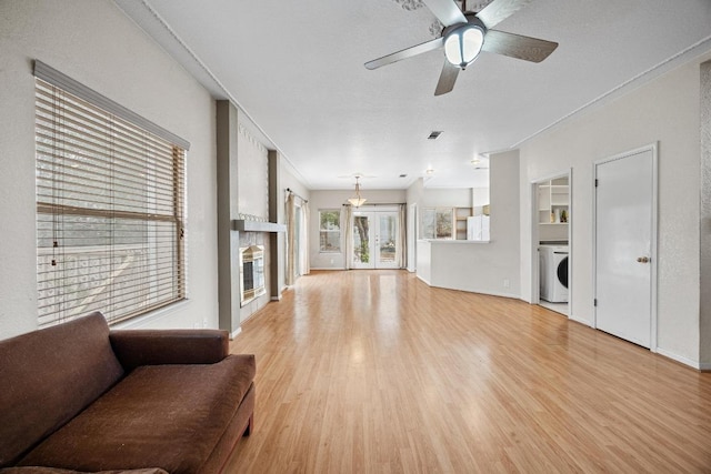1100 Silverton Ct, Austin, TX 78753 - living room with washer / dryer, light wood finished floors, a large fireplace, a ceiling fan, and baseboards