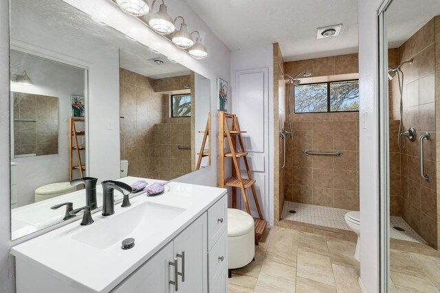 full bathroom with visible vents, vanity, toilet, and a shower stall