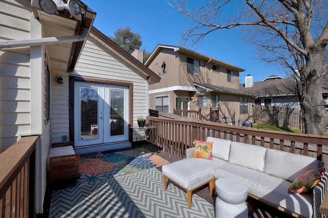 wooden terrace featuring french doors, an outdoor hangout area, and fence