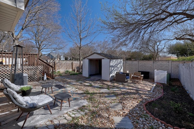 view of yard featuring a fenced backyard, a patio, an outdoor structure, and a shed