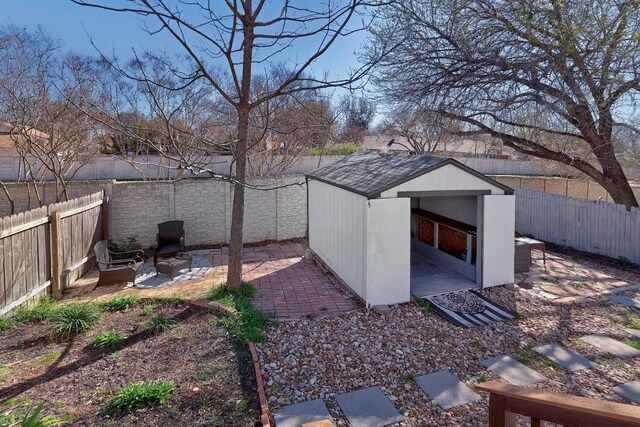 view of yard featuring an outbuilding, a shed, a patio area, and a fenced backyard