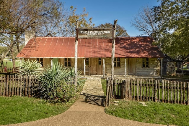 view of front of house with a porch, fence, and metal roof