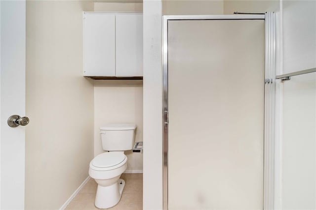 full bathroom featuring tile patterned floors, baseboards, toilet, and a stall shower