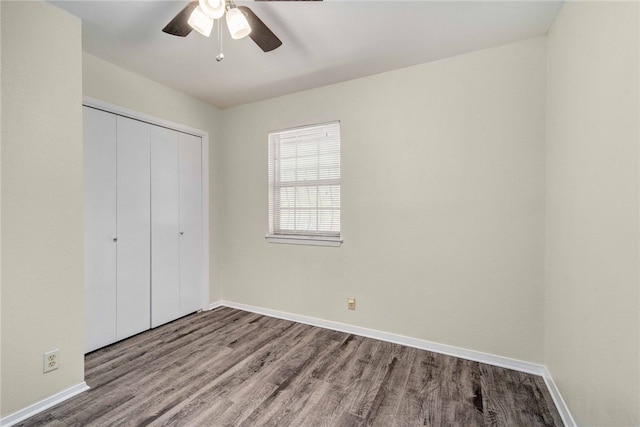 unfurnished bedroom featuring a closet, baseboards, and wood finished floors