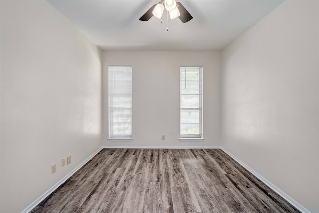 empty room featuring a ceiling fan, baseboards, and wood finished floors