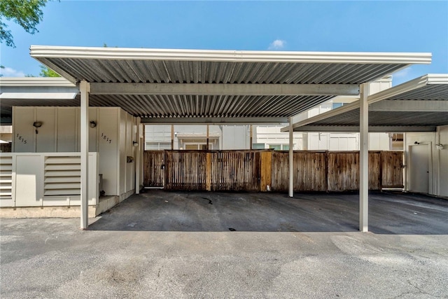 covered parking lot featuring fence