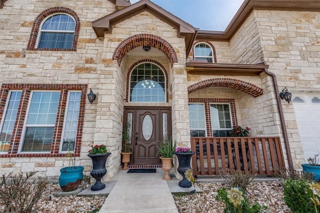 entrance to property with a garage and stone siding