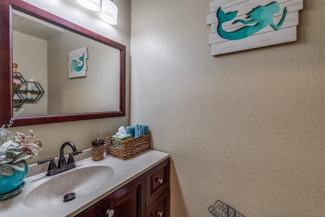 bathroom featuring vanity and a textured wall