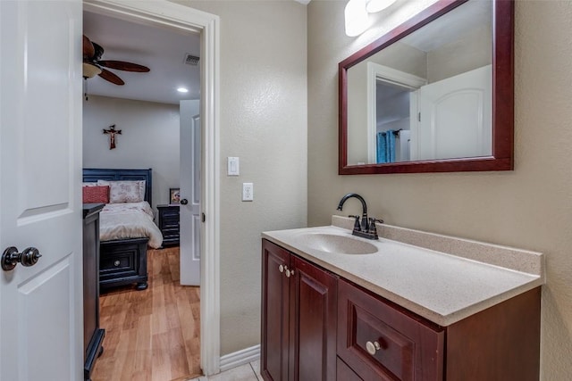 ensuite bathroom featuring visible vents, ensuite bathroom, wood finished floors, vanity, and a ceiling fan