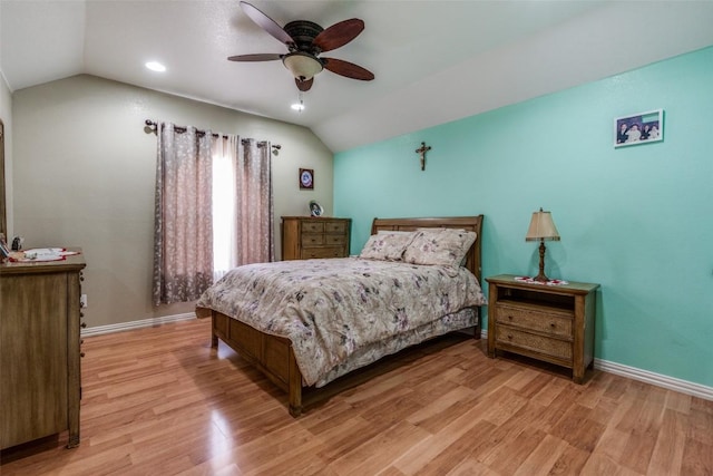 bedroom with vaulted ceiling, baseboards, and light wood finished floors