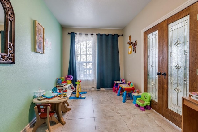 rec room with tile patterned flooring, french doors, and baseboards