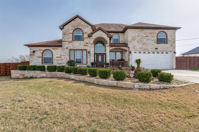 french provincial home featuring a front lawn, concrete driveway, fence, and an attached garage