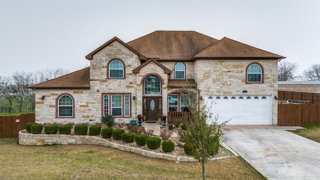 french country home with driveway, a shingled roof, a front yard, and fence