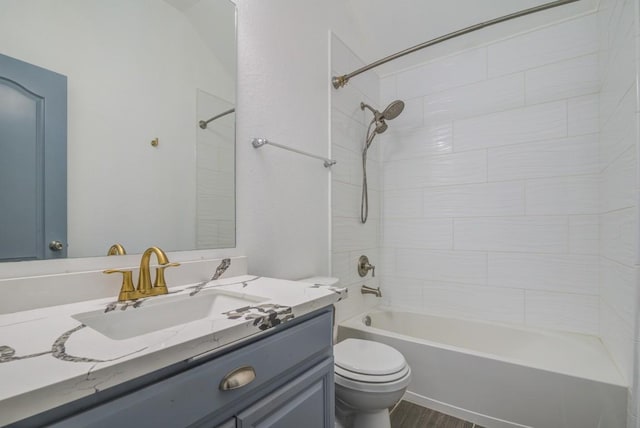 bathroom with vanity, toilet, wood finished floors, and shower / bath combination