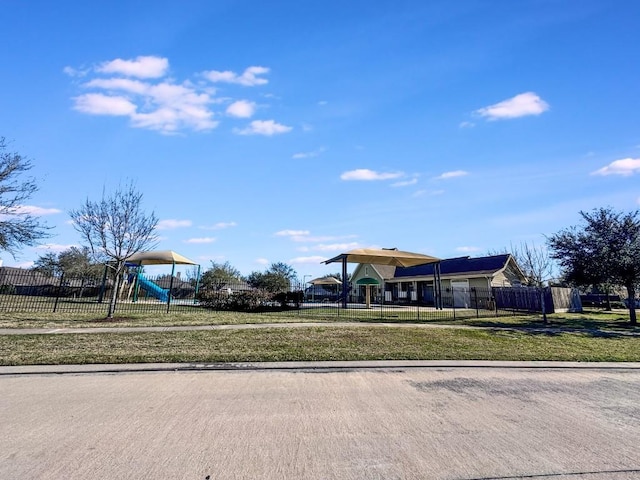 community playground featuring a yard and fence