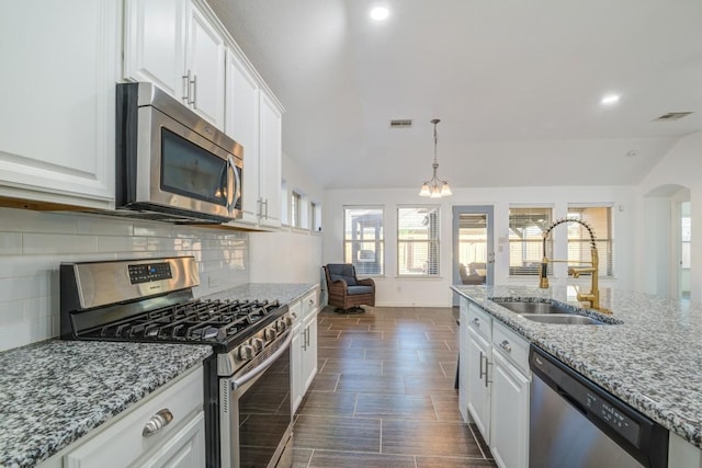 kitchen with visible vents, a sink, white cabinetry, appliances with stainless steel finishes, and decorative backsplash