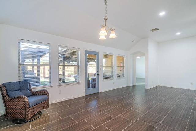 sitting room with visible vents, baseboards, a chandelier, vaulted ceiling, and arched walkways