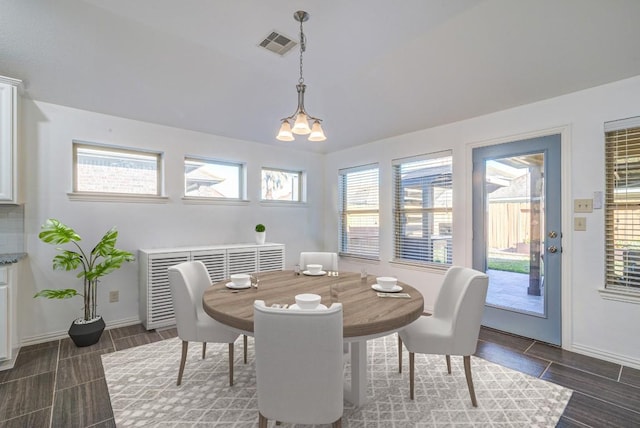 dining area with wood finish floors, visible vents, baseboards, and an inviting chandelier