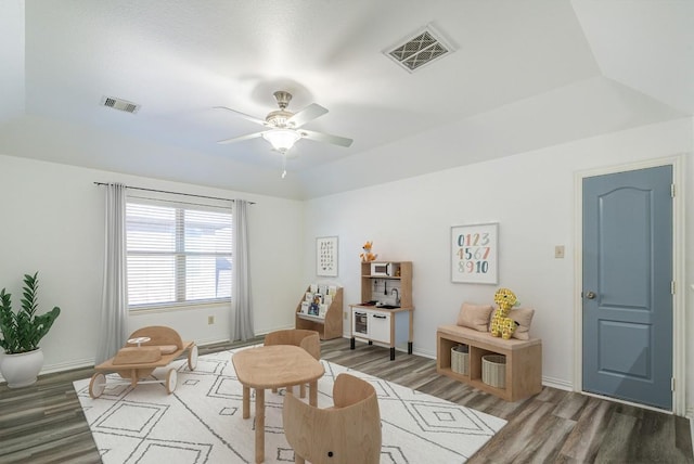 rec room featuring visible vents, a tray ceiling, and wood finished floors