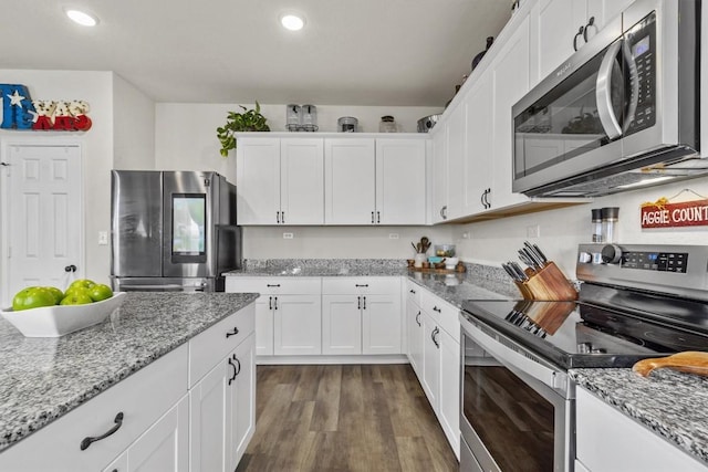 kitchen with dark wood-type flooring, white cabinetry, recessed lighting, stainless steel appliances, and light stone countertops