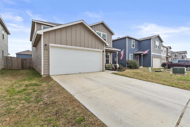 view of front of property featuring fence, an attached garage, concrete driveway, a front lawn, and board and batten siding