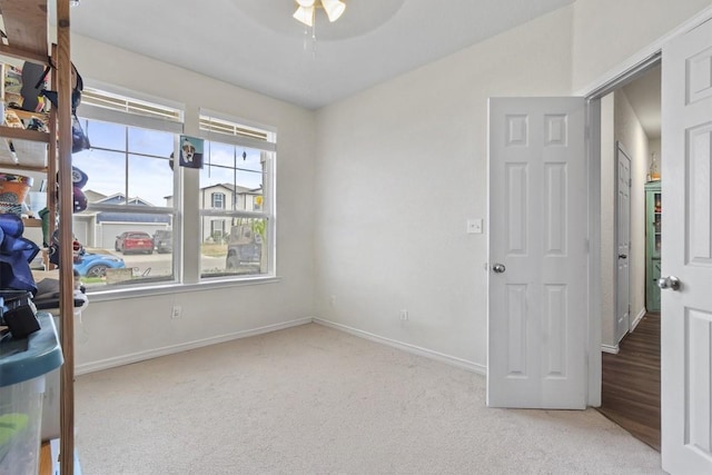 unfurnished office featuring baseboards, carpet, and ceiling fan