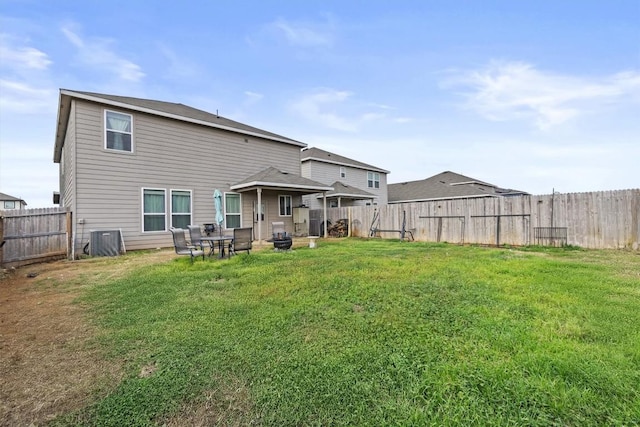 rear view of house with a lawn and a fenced backyard