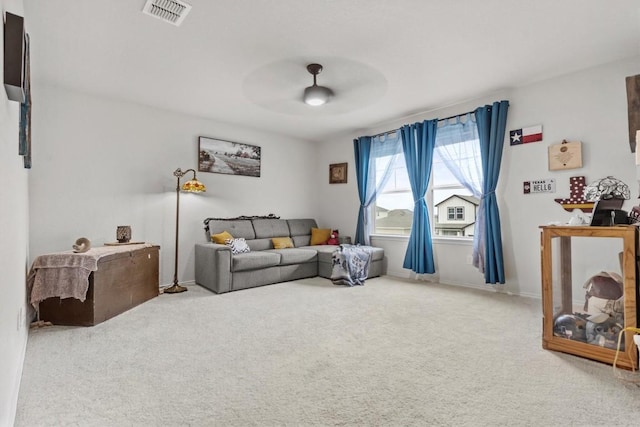 carpeted living room with visible vents and ceiling fan