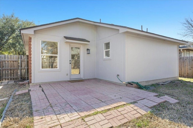 rear view of house featuring a patio area and fence