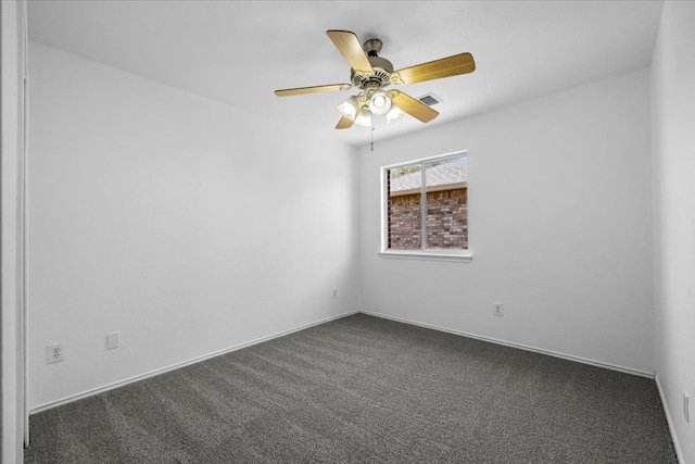 empty room featuring a ceiling fan, visible vents, dark colored carpet, and baseboards