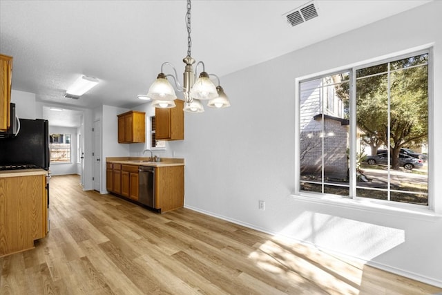 kitchen featuring light wood-type flooring, brown cabinets, visible vents, a sink, and dishwasher