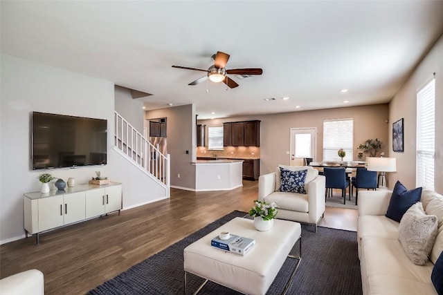 living area with recessed lighting, stairway, plenty of natural light, and wood finished floors