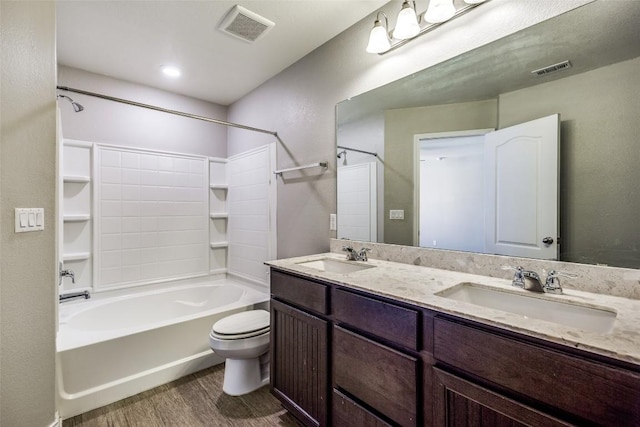 full bathroom with visible vents, toilet, wood finished floors, and a sink