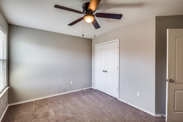 unfurnished bedroom featuring a ceiling fan, carpet, and baseboards