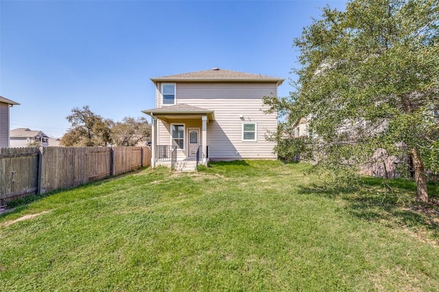 back of house with a lawn and fence