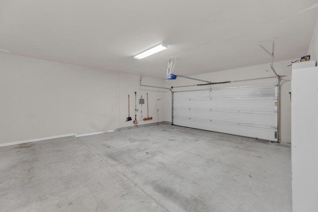 garage with a garage door opener and baseboards