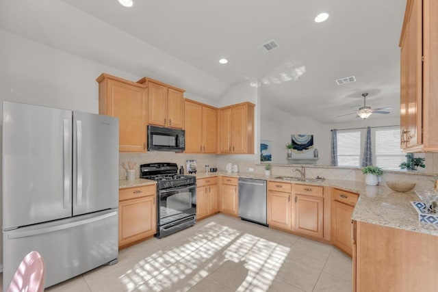 kitchen featuring lofted ceiling, backsplash, black appliances, and light brown cabinetry