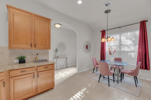 dining area with light tile patterned floors, visible vents, baseboards, recessed lighting, and arched walkways