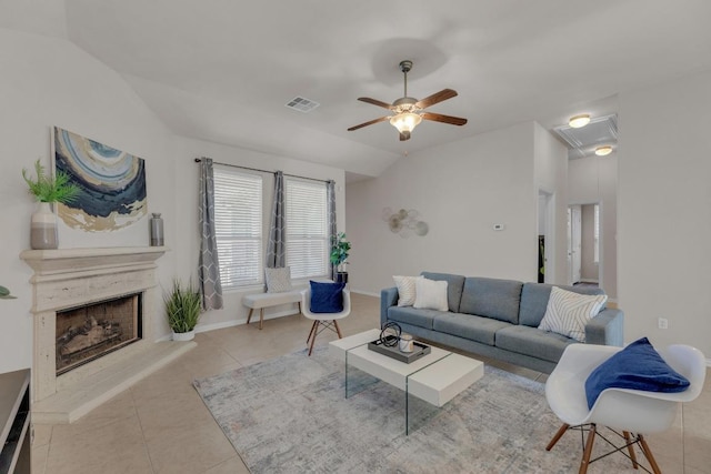 living room with visible vents, vaulted ceiling, light tile patterned floors, a fireplace, and a ceiling fan