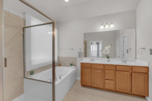 bathroom featuring double vanity, a sink, tile patterned flooring, a shower stall, and a garden tub