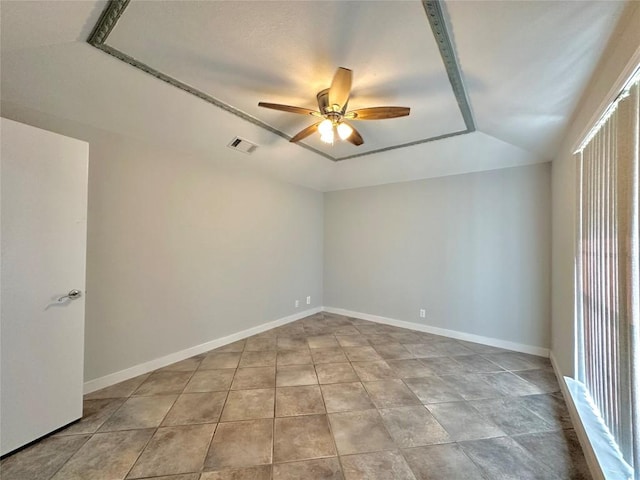 empty room featuring light tile patterned floors, visible vents, baseboards, and ceiling fan