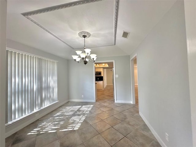 tiled empty room featuring visible vents, a raised ceiling, baseboards, and a chandelier