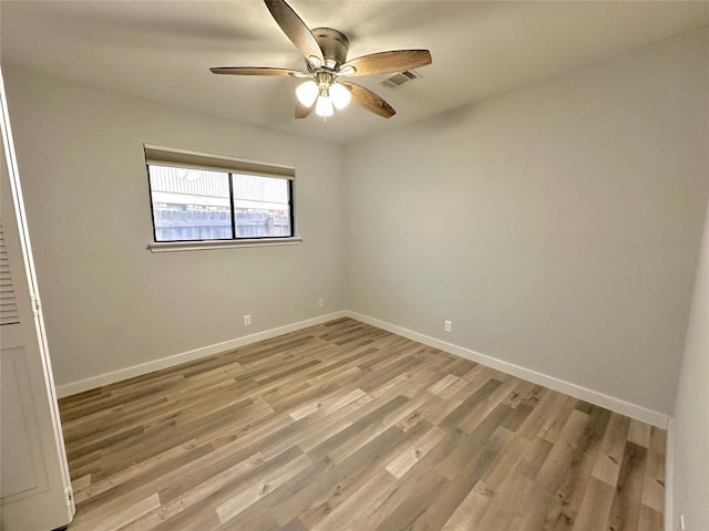 spare room featuring visible vents, baseboards, light wood-style flooring, and a ceiling fan